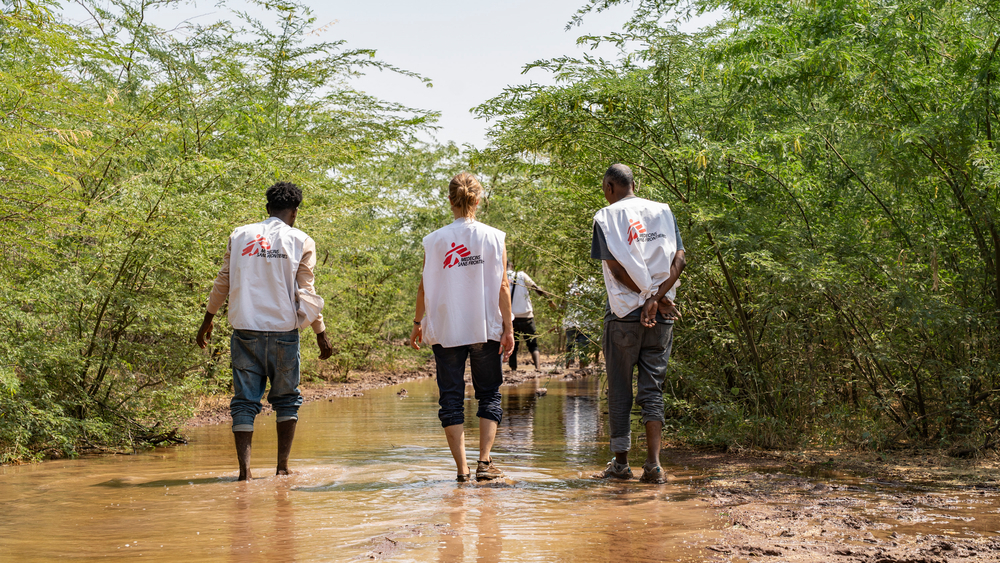 msf employees walking through mud