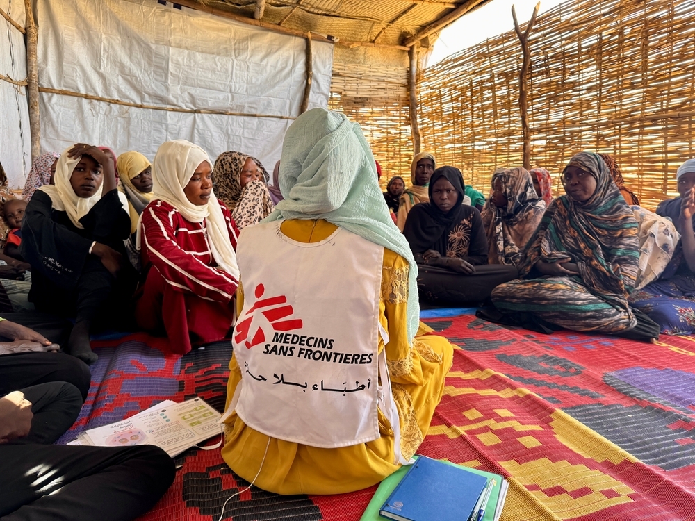 msf employee sitting down and talking to a group of women