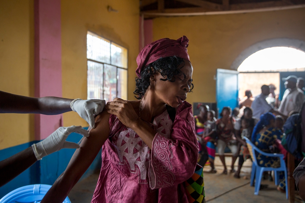 Een vrouw wordt gevaccineerd tegen gele koorts en kijkt pijnlijk weg. © MSF