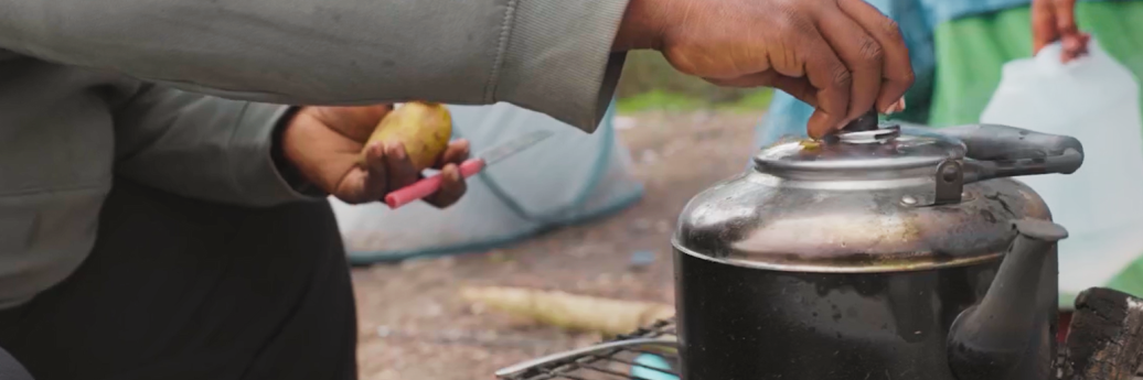 personne cuisinne sur un feu improvisé