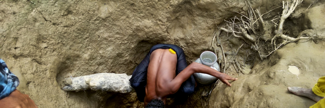 Een man haalt water uit een met de hand gegraven waterput in het kamp Unchiparang. Maar ook op drie meter diepte is water niet noodzakelijk drinkbaar. © Paul Andrew Jabor/AZG