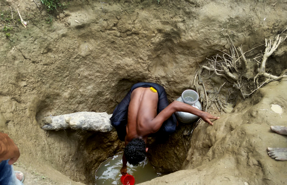 Een man haalt water uit een met de hand gegraven waterput in het kamp Unchiparang. Maar ook op drie meter diepte is water niet noodzakelijk drinkbaar. © Paul Andrew Jabor/AZG